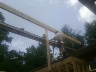 Carpenter setting a ridge beam over a new addition frame — Ice Dam Removal by Roofing Brothers in Yelm