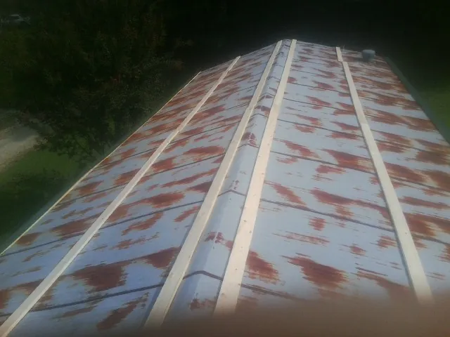 Rusted metal roof panels with new wood purlins before replacement — Storm Damage Roof Repair in Yelm by Roofing Brothers
