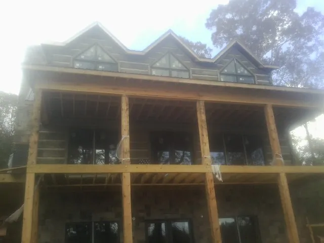 Dormers and porch framing on a large log home under construction — Roof Coating work by our crew in Yelm