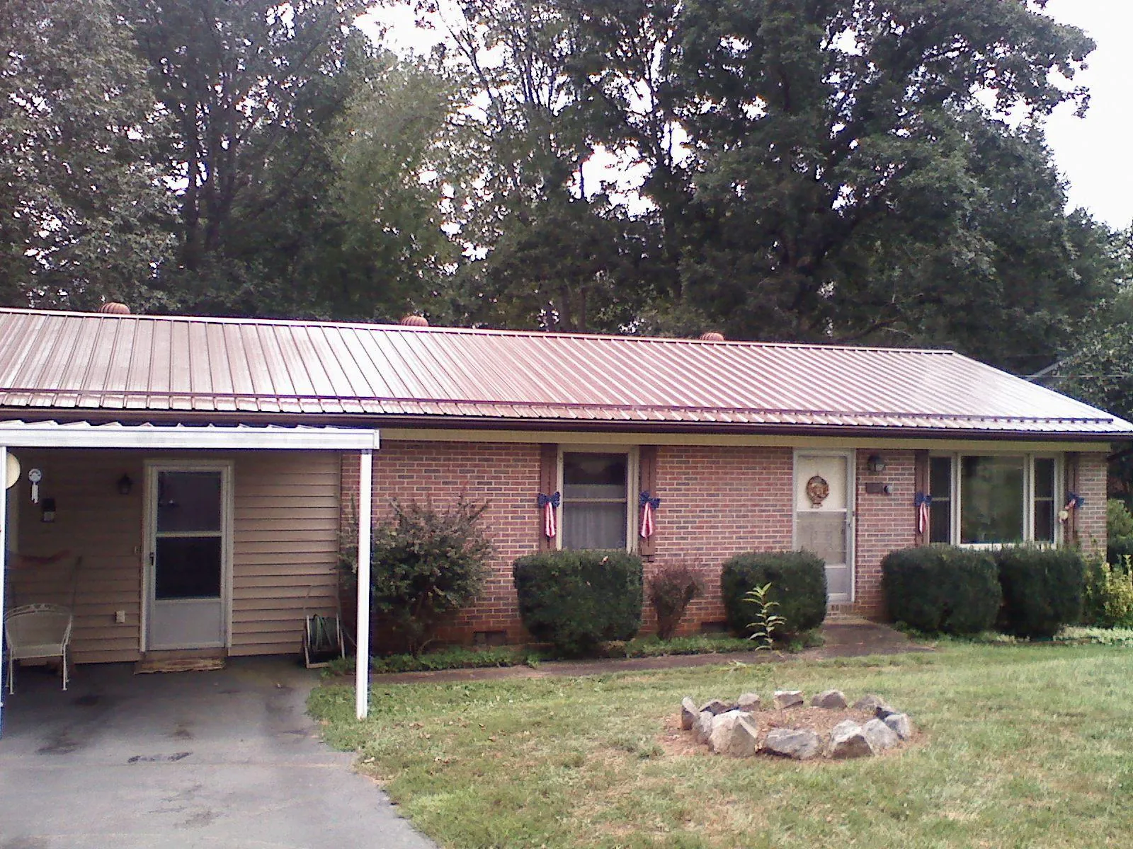 Bronze metal roof and carport on a brick ranch home — Roof Repair work by our crew in Yelm